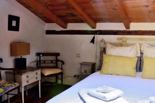 a bedroom with a white bed and a wooden ceiling at 'La Casa de LoLa' casita de cuento con terraza in Arenas de San Pedro