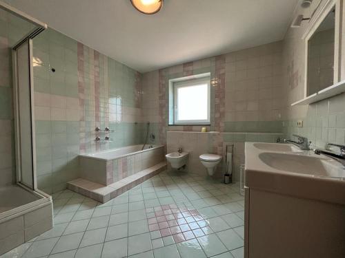 y baño con bañera, aseo y lavamanos. en Ferienwohnungen Pesenbachtal en Herzogsdorf