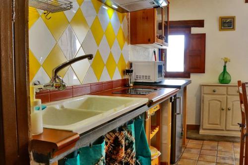 una cucina con lavandino e piano cottura forno superiore di 'La Casa de LoLa' casita de cuento con terraza ad Arenas de San Pedro
