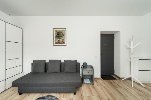 a bedroom with a bed and a white wall at Zalgirio Arena Apartment No1 by URBAN RENT in Kaunas