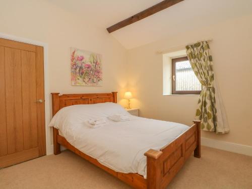 a bedroom with a bed and a window at Swallows Return in Macclesfield