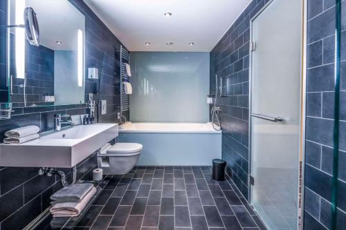 فندق سانديك بالاس في كوبنهاغن: حمام مع حوض ومرحاض وحوض استحمام