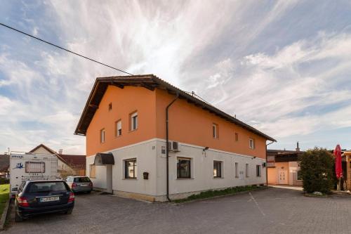 a orange and white building in a parking lot at Apartments Keber in Ljubljana