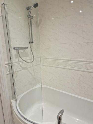 a shower with a glass door next to a tub at Tees Valley Apartments in Middlesbrough