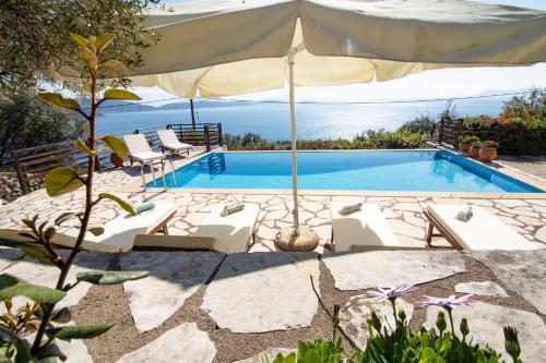 a swimming pool with chairs and an umbrella at The Lookout, boutique villa. in Sivota