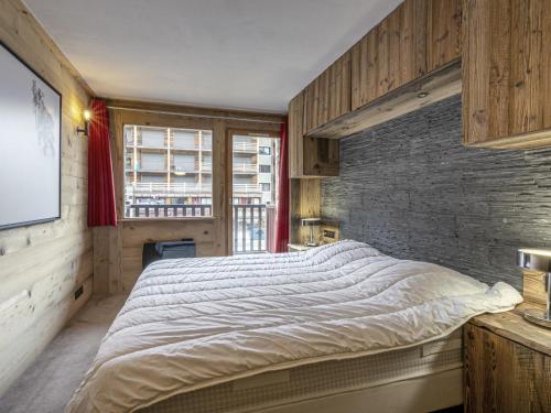 a bedroom with a large bed and a brick wall at Appartement ski aux pieds, centre Val d'Isère, jusqu'à 6 pers, WIFI - FR-1-519-31 in Val dʼIsère