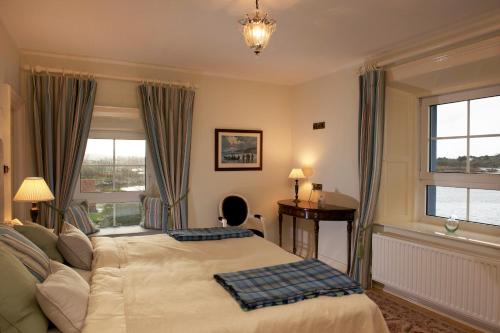 a bedroom with a bed and a desk and windows at Screebe House in Rosmuck