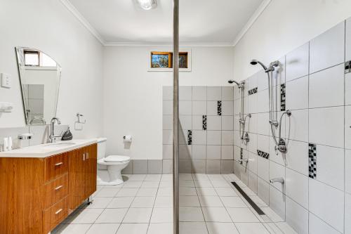 a bathroom with a shower and a sink and a toilet at Goolwa River Retreat in Torrumbarry