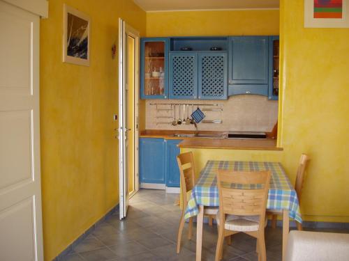 una cucina con armadi blu, tavolo e sedie di Residence Ammiraglia Baia Verde a Gallipoli