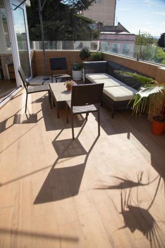 a patio with two chairs and a table on a deck at Alojamientos Puerta Palma con vistas y Parking in Badajoz