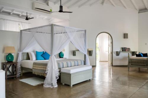 a bedroom with a bed with a canopy at Bellini Blue in Unawatuna