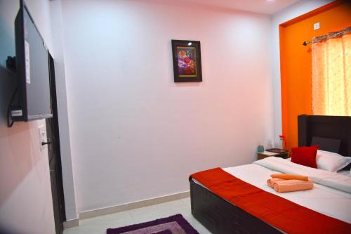 a room with a bed with orange and white at Tapovan Resort in Rishīkesh