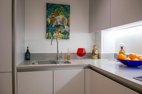 een keuken met een wastafel en een kom sinaasappels bij The Portobello Apartment in Londen