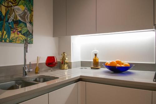 een keuken met een wastafel en een kom sinaasappels bij The Portobello Apartment in Londen
