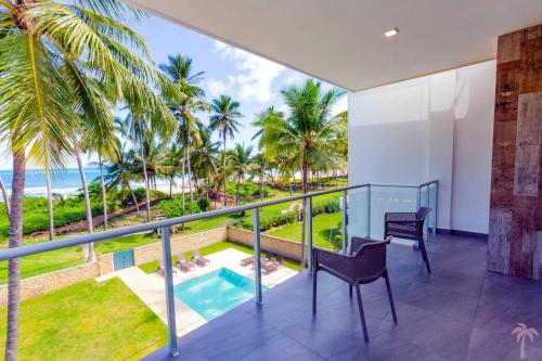 a balcony with a view of the ocean and palm trees at Villa Blue Amber Cabarete in Cabarete
