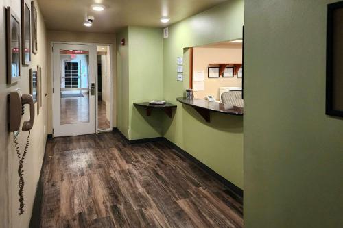 einen Flur mit einem Zimmer mit grünen Wänden und Holzböden in der Unterkunft Suburban Studios in Dickinson