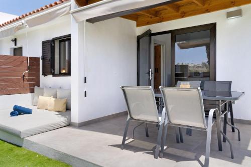 a patio with a table and chairs and a balcony at Casa Luna Kingbed and Jacuzzi in Maspalomas
