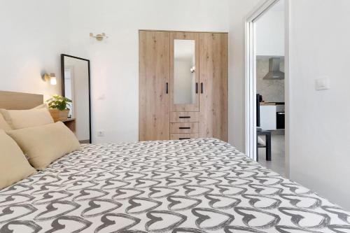 a bedroom with a large bed with a wooden door at Casa Luna Kingbed and Jacuzzi in Maspalomas
