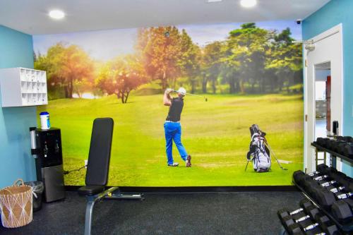 Ein TV-Bildschirm zeigt einen Mann, der auf einem Feld Golf spielt. in der Unterkunft Clarion Pointe Vidalia - Lyons West in Vidalia