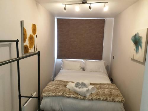 Un pequeño dormitorio con una cama con una toalla. en Birmingham Garnet 3-bedroom Apartment City Centre, en Birmingham