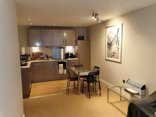 cocina y comedor con mesa y sillas en Birmingham Ruby 2-bedroom Apartment City Centre, en Birmingham