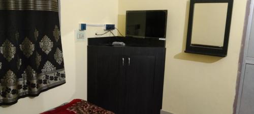 a bathroom with a black cabinet and a mirror at NEW MILAN PALACE, Deoghar in Deoghar