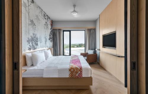 a hotel room with a bed and a television at Ginger Chandigarh, Zirakpur in Zirakpur