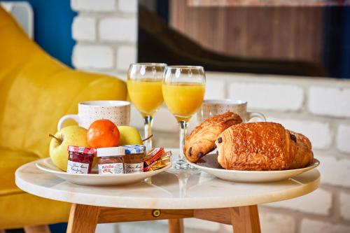 una mesa con pan y dos vasos de zumo de naranja en SO CHIC - Le Domaine Wambrechies, en Wambrechies