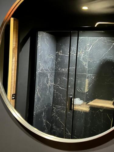 une salle de bains avec miroir réfléchissant une porte en verre. dans l'établissement SO CHIC - Le Domaine Wambrechies, à Wambrechies