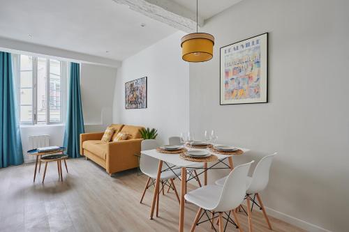 un salon blanc avec une table et des chaises dans l'établissement Residence Center of Paris by Studio prestige, à Paris