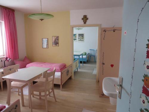 a room with a table and a bed and a dining room at Gästehaus Huber - traditional Sixties Hostel in Feichten