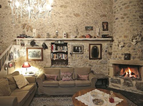 a living room with a couch and a fireplace at "Thimises" traditional-stone village house in Kharasón