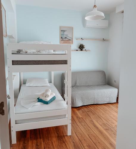 a white bunk bed in a small room with a couch at NEW Cozy Garden Apartment Pool & Terrace near Sea for up to 6 people in Akanthou
