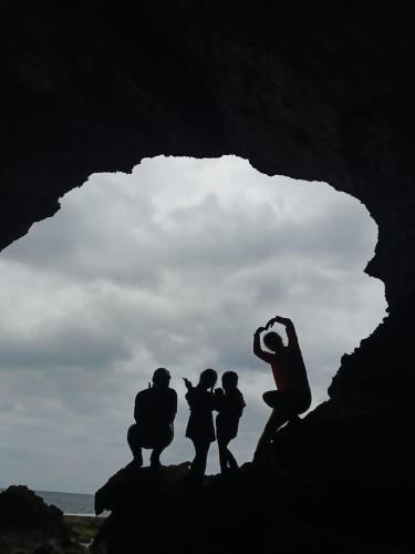 a silhouette of three people sitting on a rock at 20ft Sea Attic in Green Island