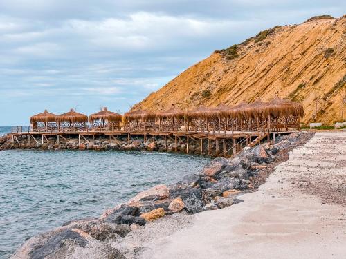 a wooden bridge over the water next to a beach at NEW Cozy Garden Apartment Pool & Terrace near Sea for up to 6 people in Akanthou