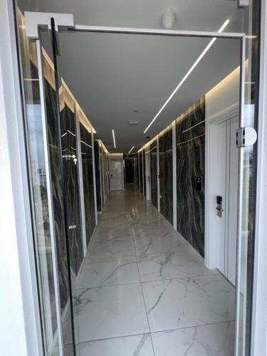 a hallway of a building with marble floors and glass doors at Ilio Boutique Hotel in Ksamil