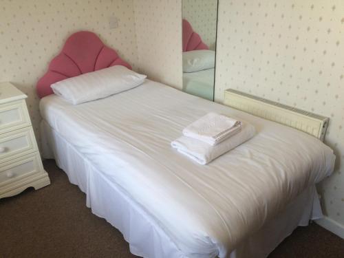 a bedroom with a bed with two towels on it at The Wight Bay Hotel - Isle of Wight in Sandown