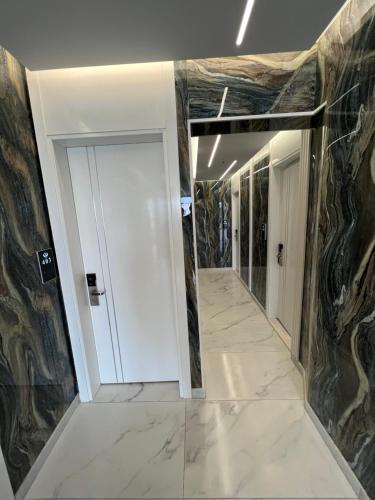 a hallway with marble floors and a white door at Ilio Boutique Hotel in Ksamil
