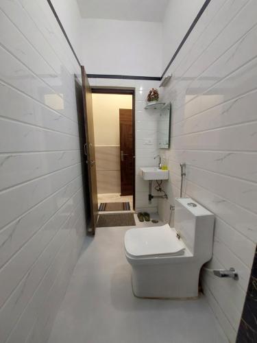 uma casa de banho com um WC branco e um lavatório. em Taj Nice Point Manage by Taj Sunrise Group em Agra