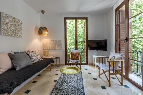 ein Wohnzimmer mit einem Sofa und einem TV in der Unterkunft Mesones 54 in Granada