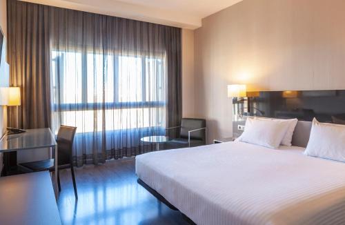 a hotel room with a bed and a large window at Porcel Torneo in Seville