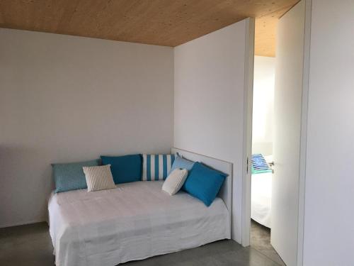 Schlafzimmer mit einem Bett mit blauen und weißen Kissen in der Unterkunft Ferienhaus am See Neusiedl in Neusiedl am See