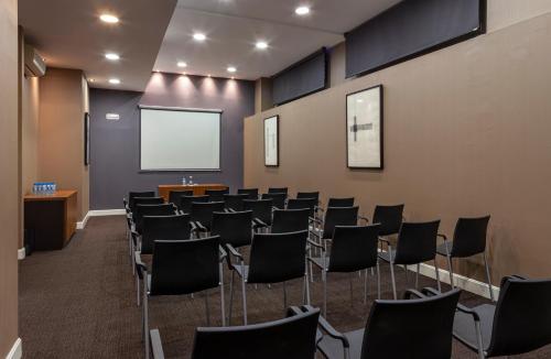 a conference room with chairs and a white screen at Porcel Torneo in Seville