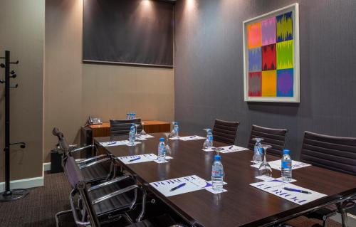 a conference room with a table and chairs with water bottles at Porcel Torneo in Seville