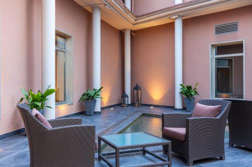 a patio with chairs and a table and a pool at Porcel Torneo in Seville