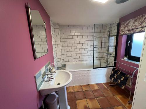 a bathroom with a sink and a bath tub at Couples retreat Boutique style Barn conversion in Great Yarmouth
