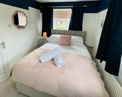 a bedroom with a bed with two towels on it at A modern cosy one bedroom home away from home in Houghton le Spring