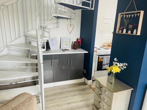 a kitchen with a spiral staircase in a room at A modern cosy one bedroom home away from home in Houghton le Spring