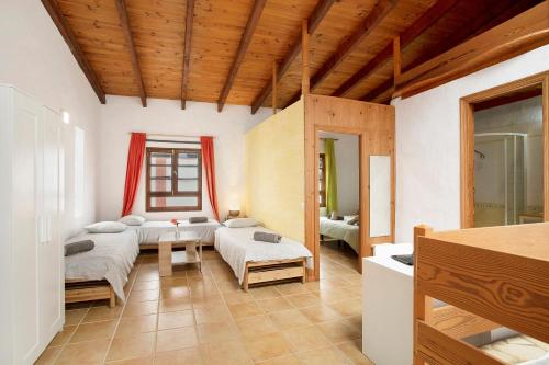 ein Wohnzimmer mit 2 Betten und einem Sofa in der Unterkunft Casa Las Flores in Moya