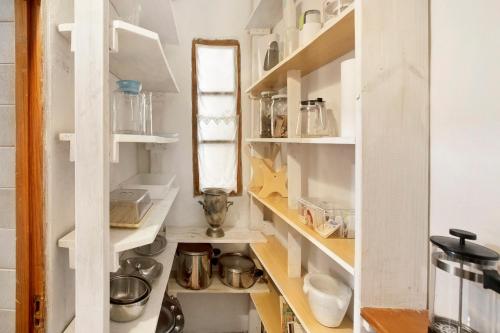 a small kitchen with white shelves and a mirror at Casa Las Flores in Moya